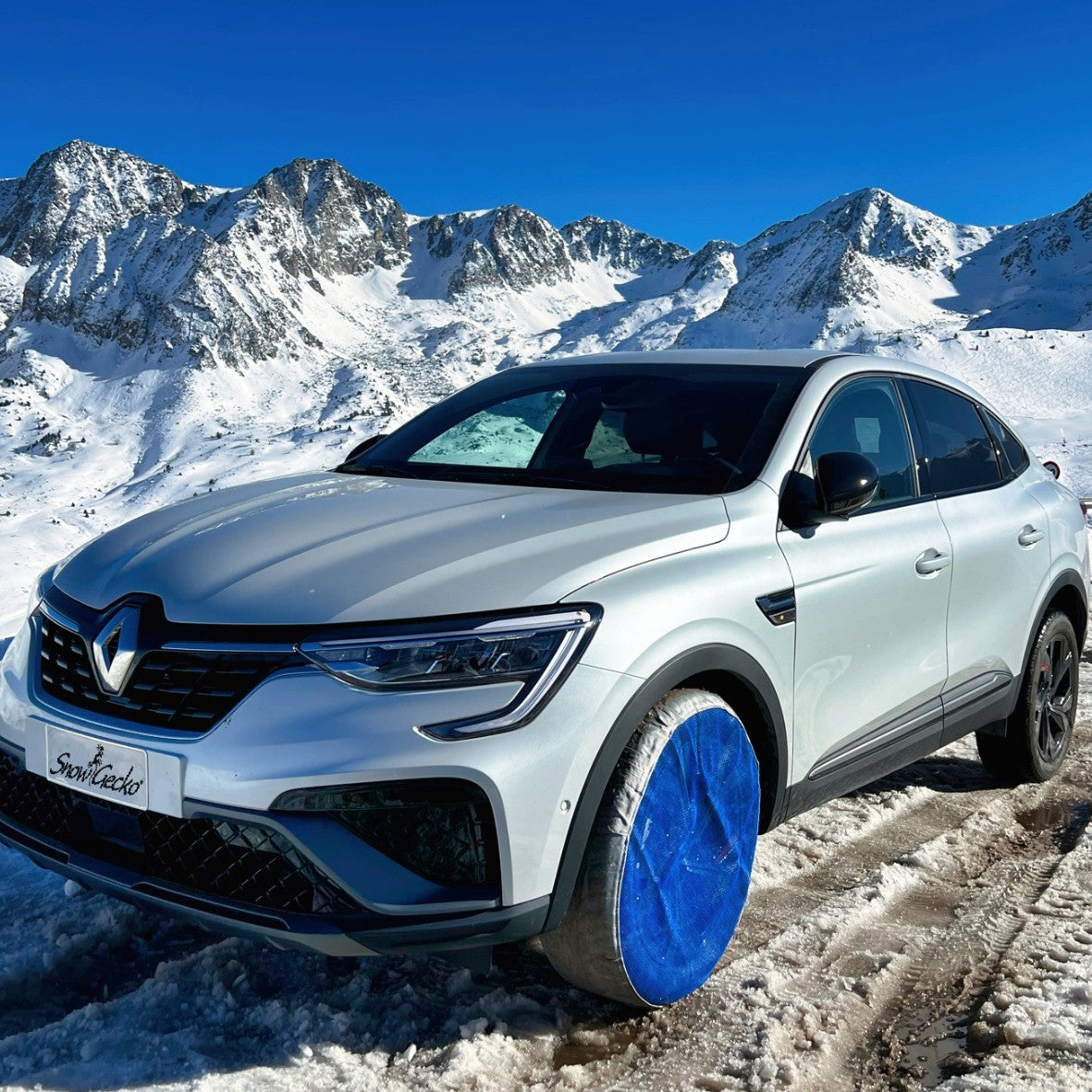Sideview of a passenger car with SnowGecko mounted, standing on snow in wintery mountain region