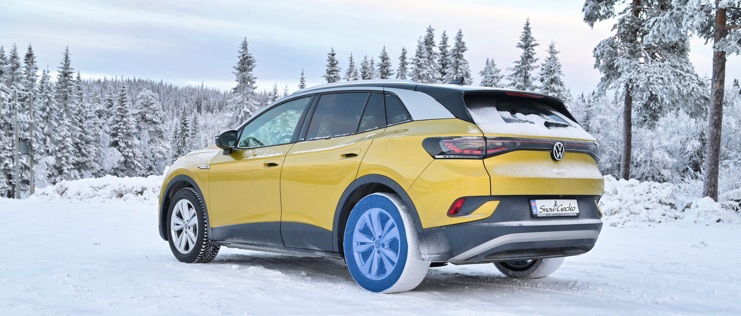 Snowgecko snow socks mounted on rear wheels of a passenger car